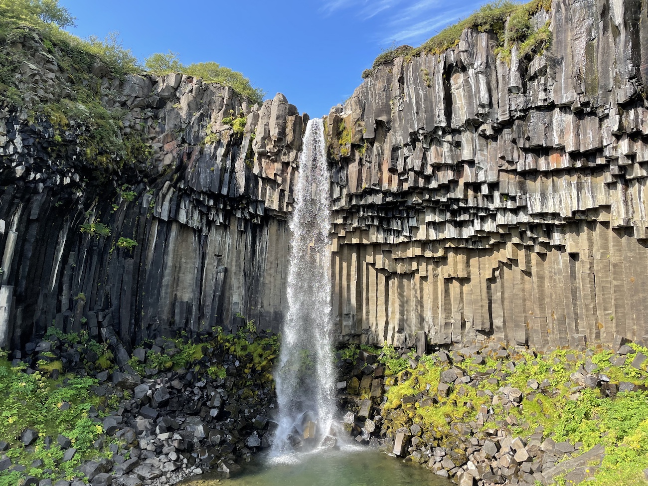 Basalt rock structures under a waterfall in Iceland